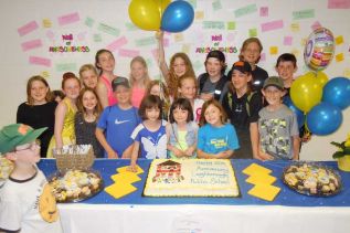 LPS students pose in front of the celebratory cake, which was later cut by John and Ginny Trousdale